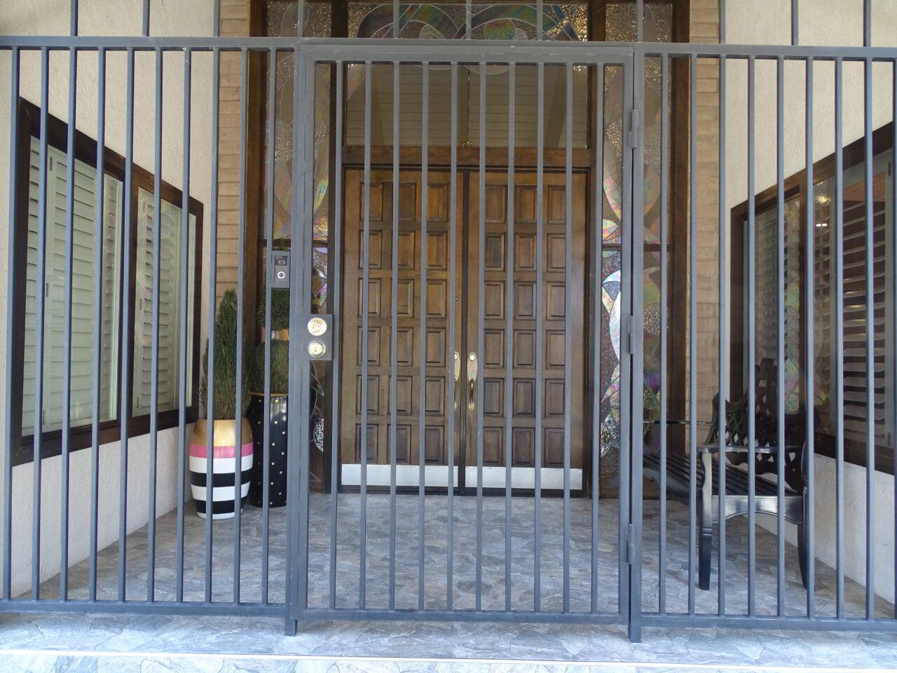 Elegant entrance with decorative gates and wooden doors.