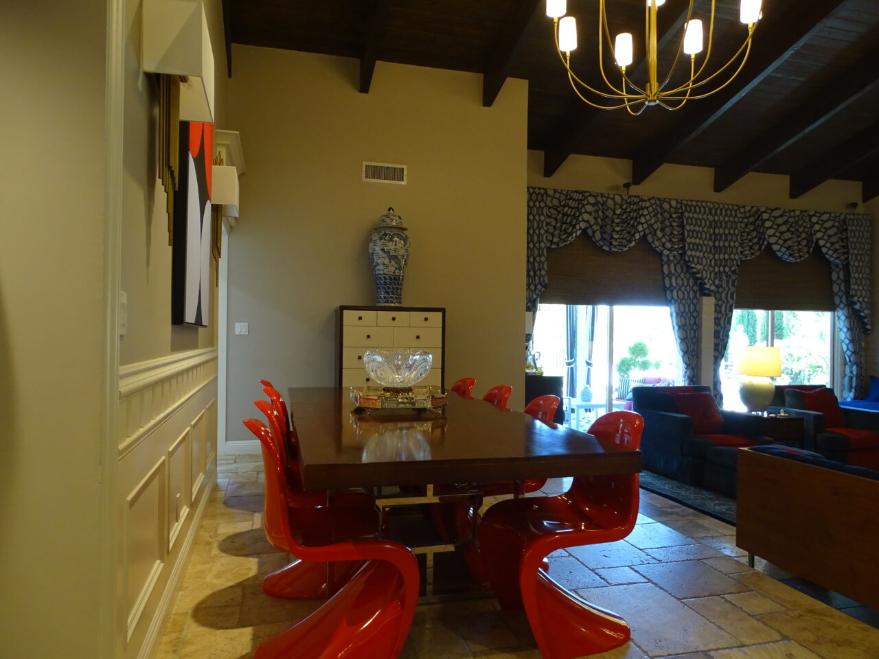 Elegant dining room with red chairs and chandelier.