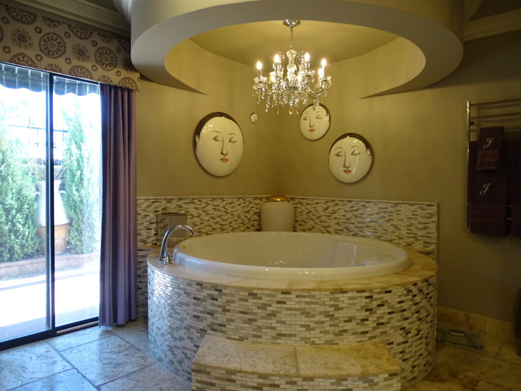 Luxurious bathroom with artistic masks and elegant tub.