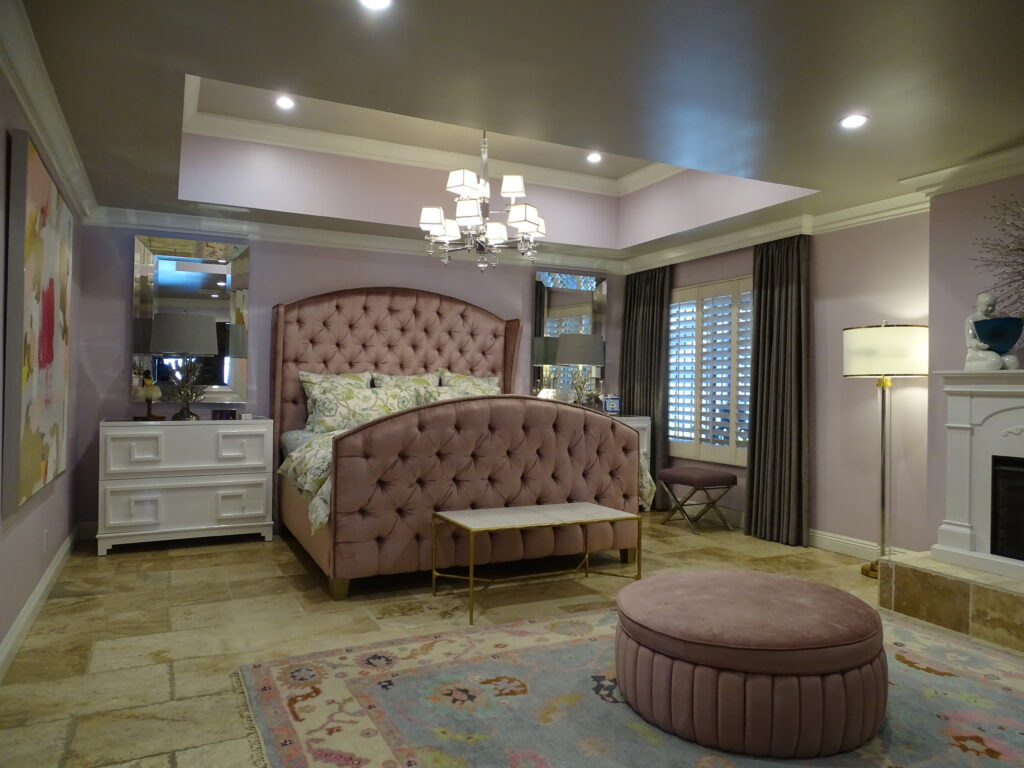 Elegant bedroom with tufted pink bed and stylish décor.