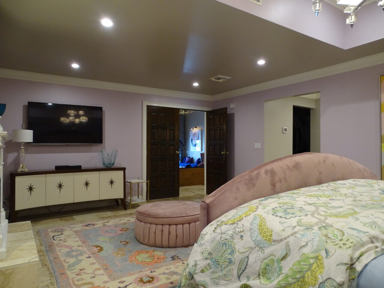 Elegant bedroom with pink velvet furnishings and floral bedding.