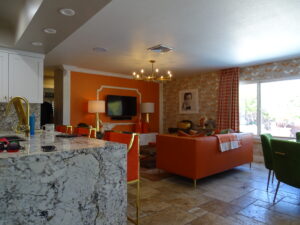 Bright, modern living room with orange and green decor.