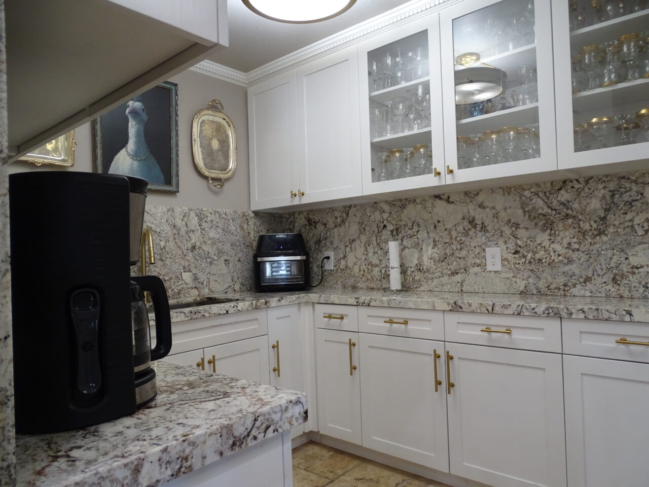 Elegant kitchen with marble countertops and white cabinetry.