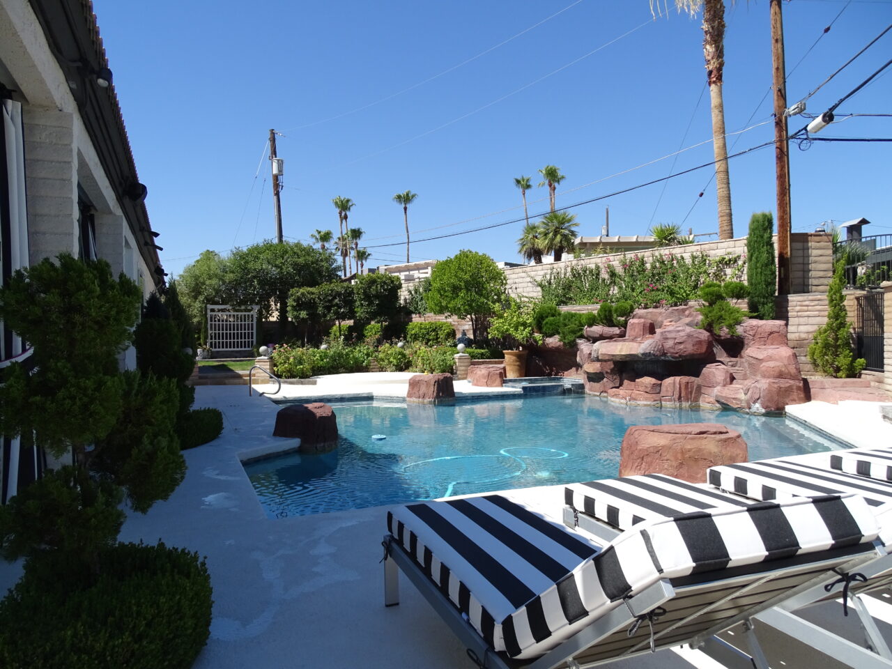 Luxurious backyard pool with waterfall and loungers.