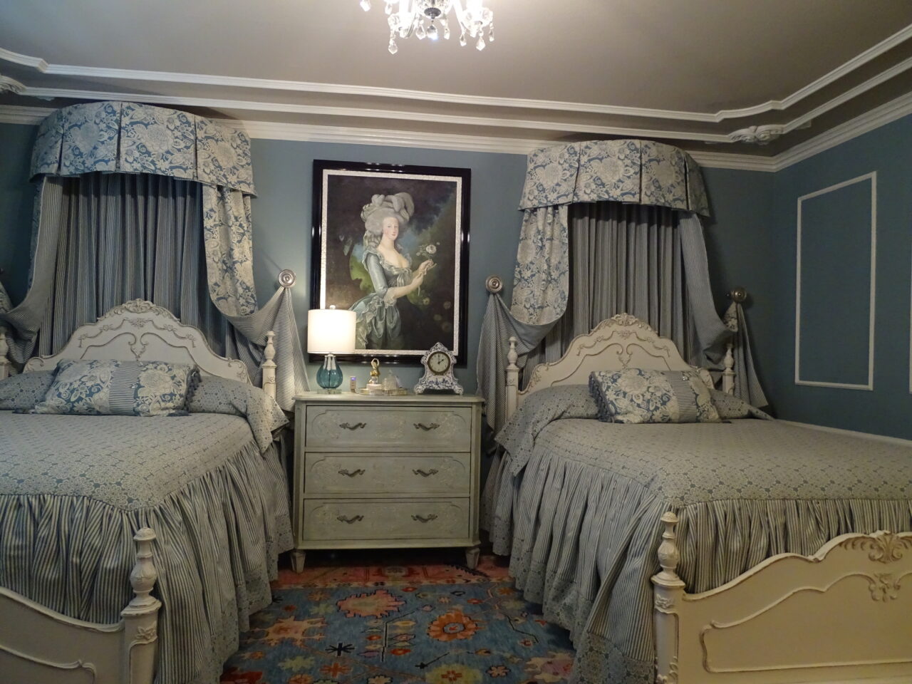 Elegant vintage twin bedroom with ornate blue decor.