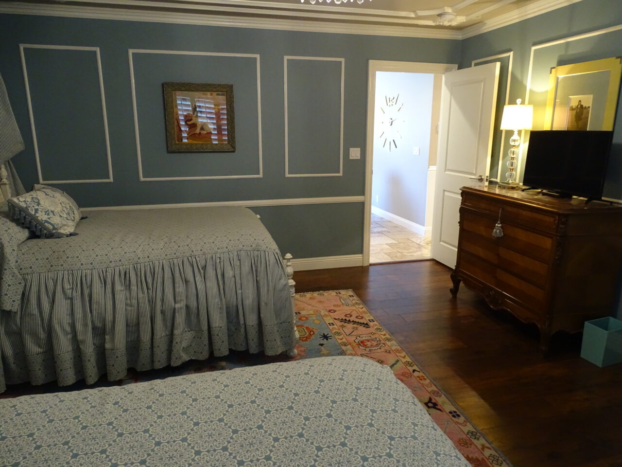 Elegant blue bedroom with vintage wooden furniture and decor.