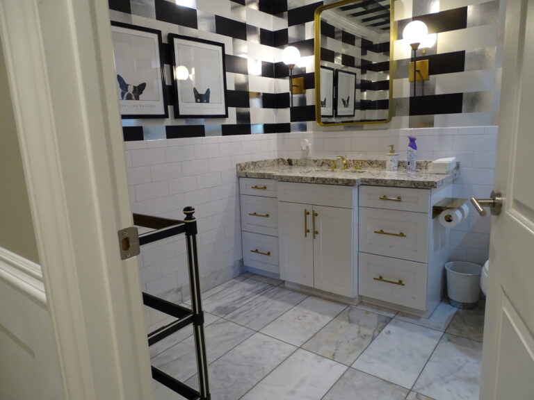 Modern black and white tiled bathroom with gold accents.