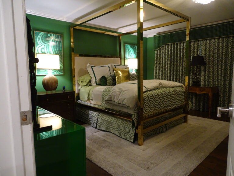 Elegant green-themed bedroom with gold-framed canopy bed.