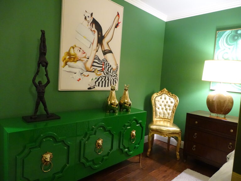 Eclectic green room with vibrant art and vintage furniture.