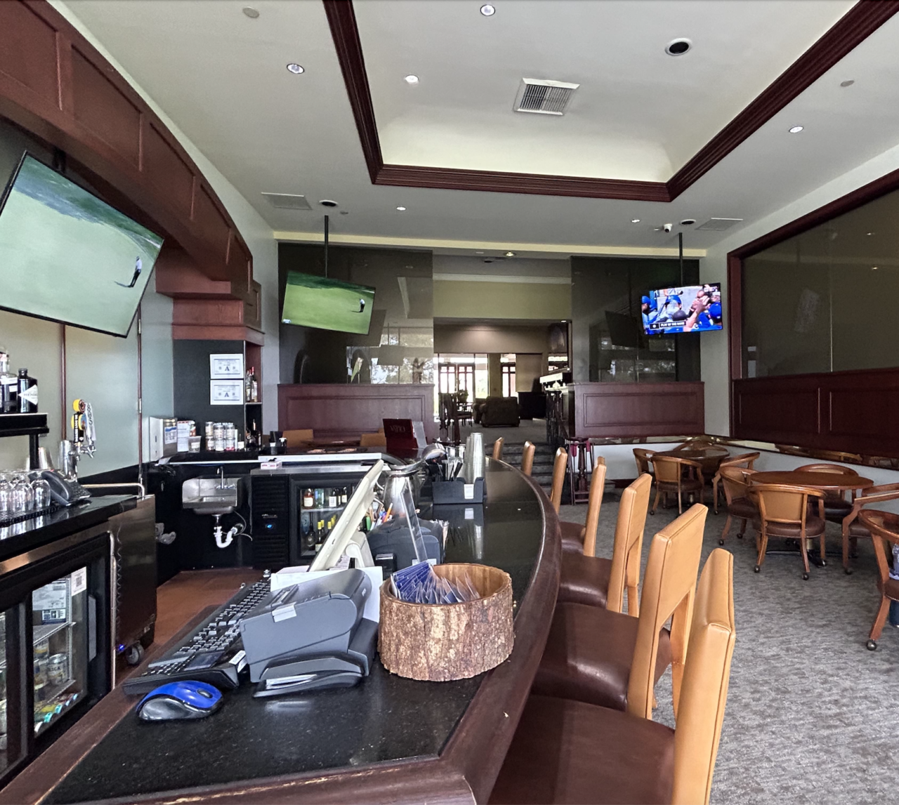 Spacious bar interior with wooden furniture and TVs