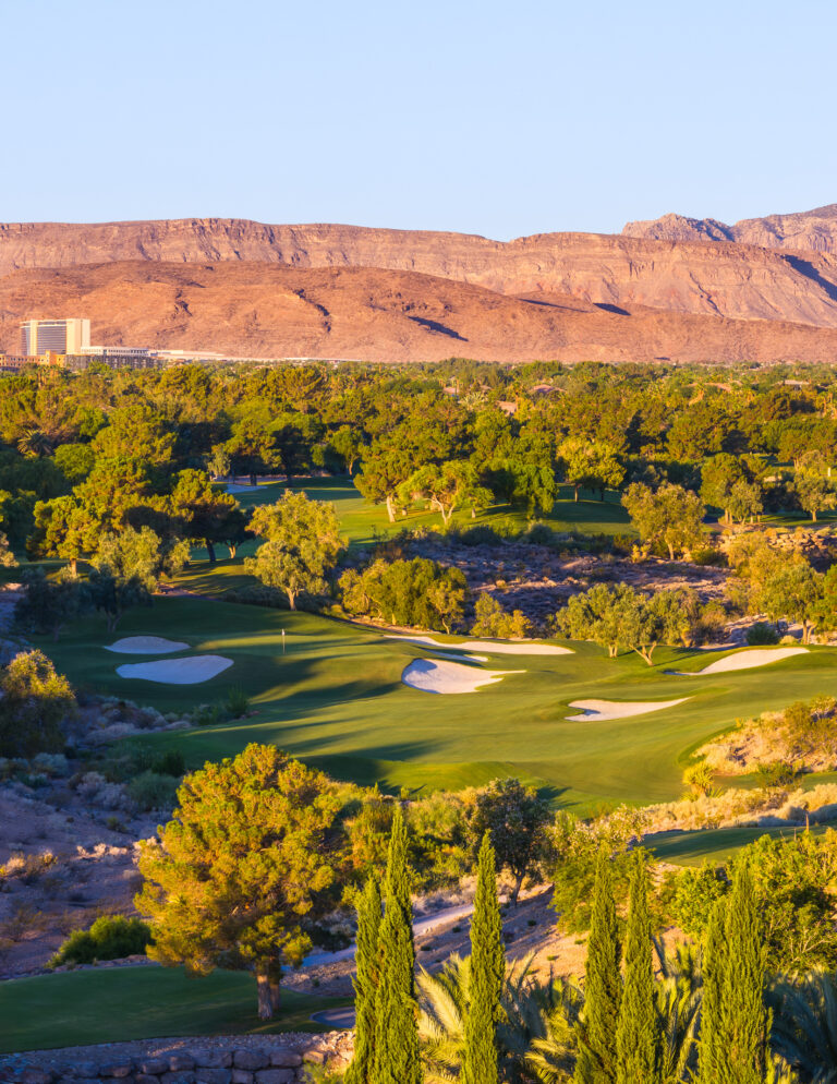 Golf course with mountain backdrop at sunset