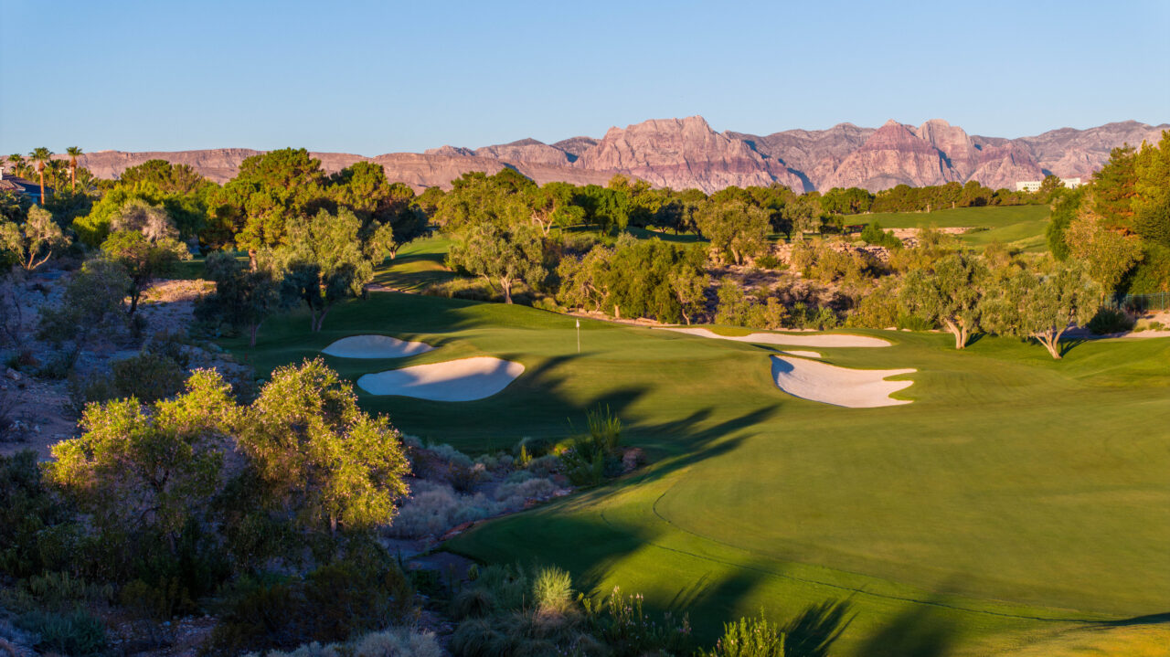 Scenic golf course with mountain backdrop at sunset