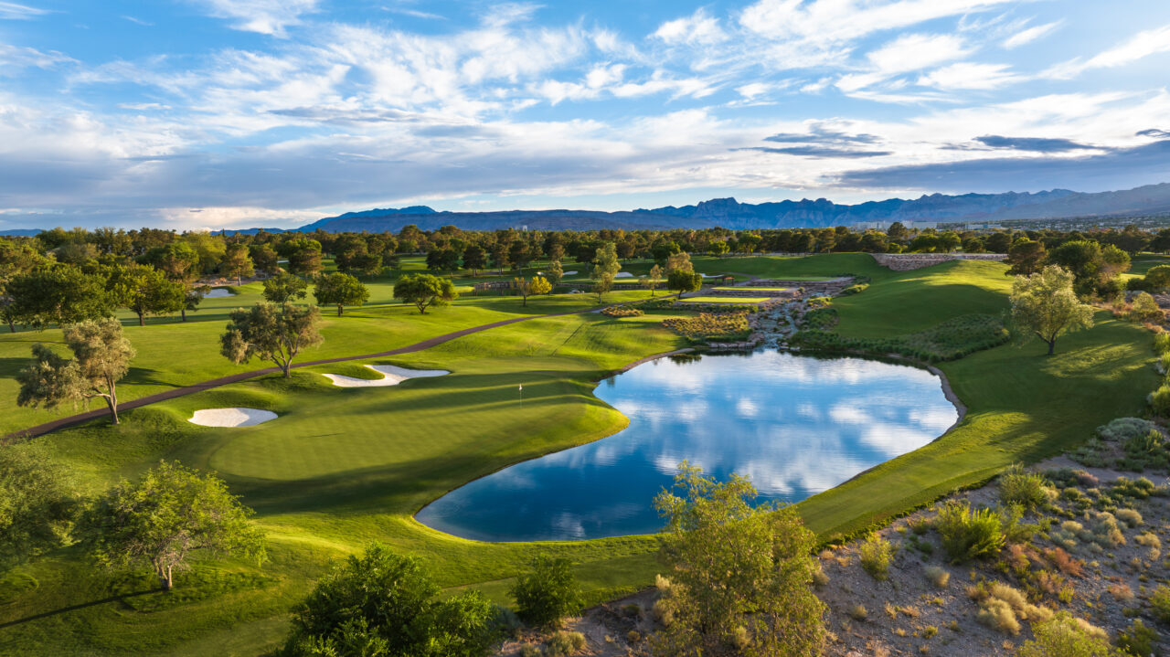 Scenic golf course with lake and mountain backdrop