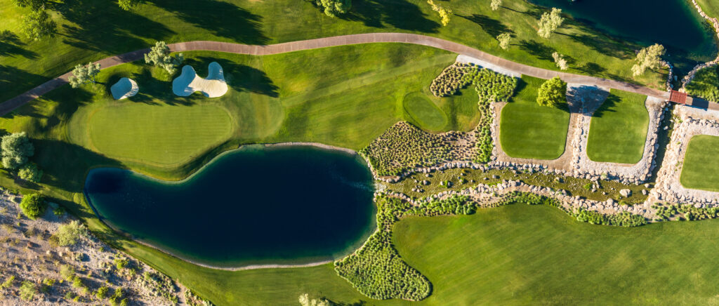 Aerial view of a lush golf course with a lake