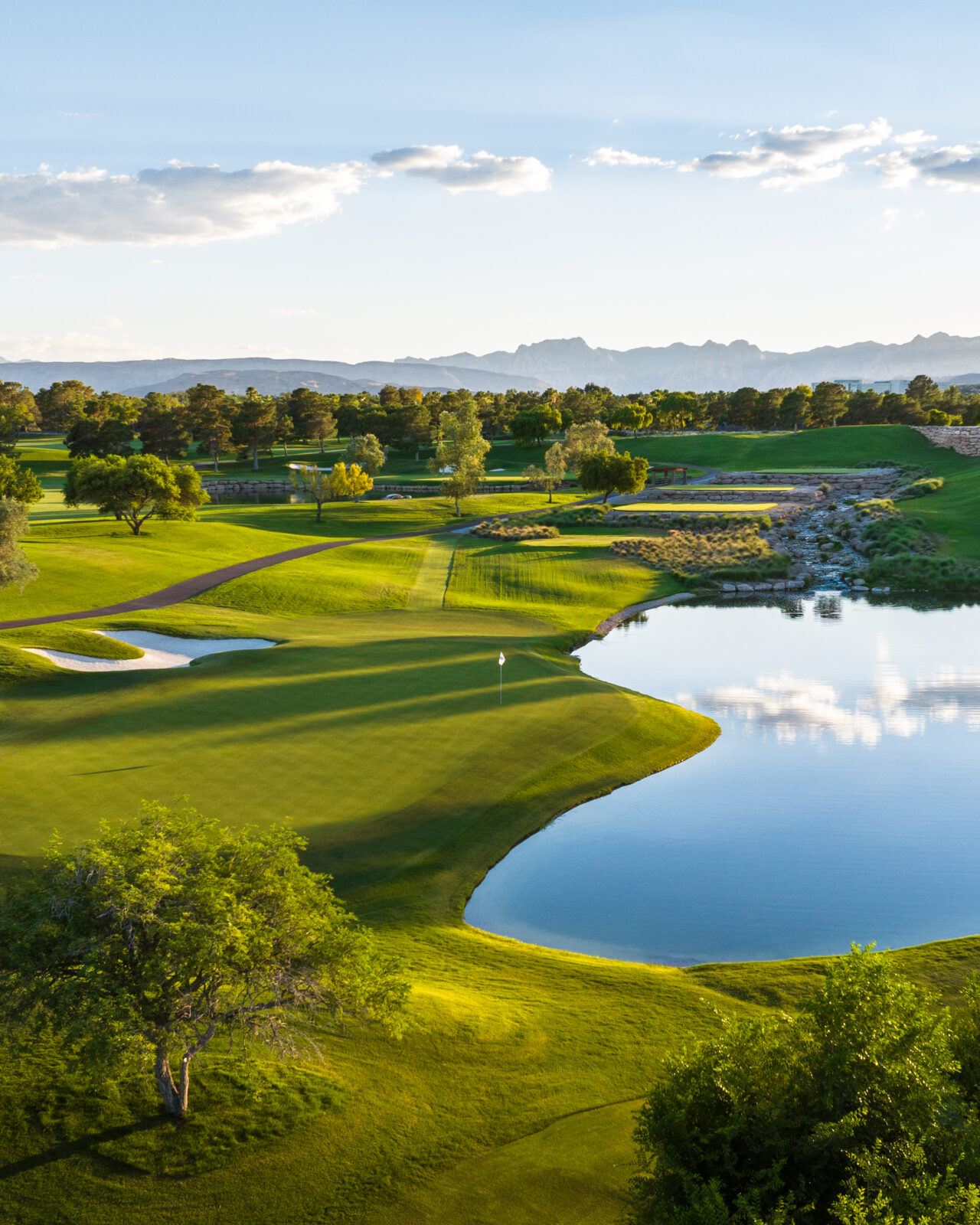 Scenic golf course with lake and distant mountains