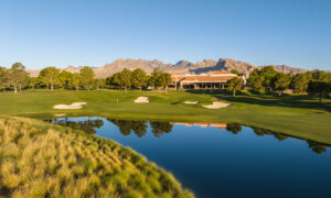 Golf course with mountain backdrop, scenic pond reflections