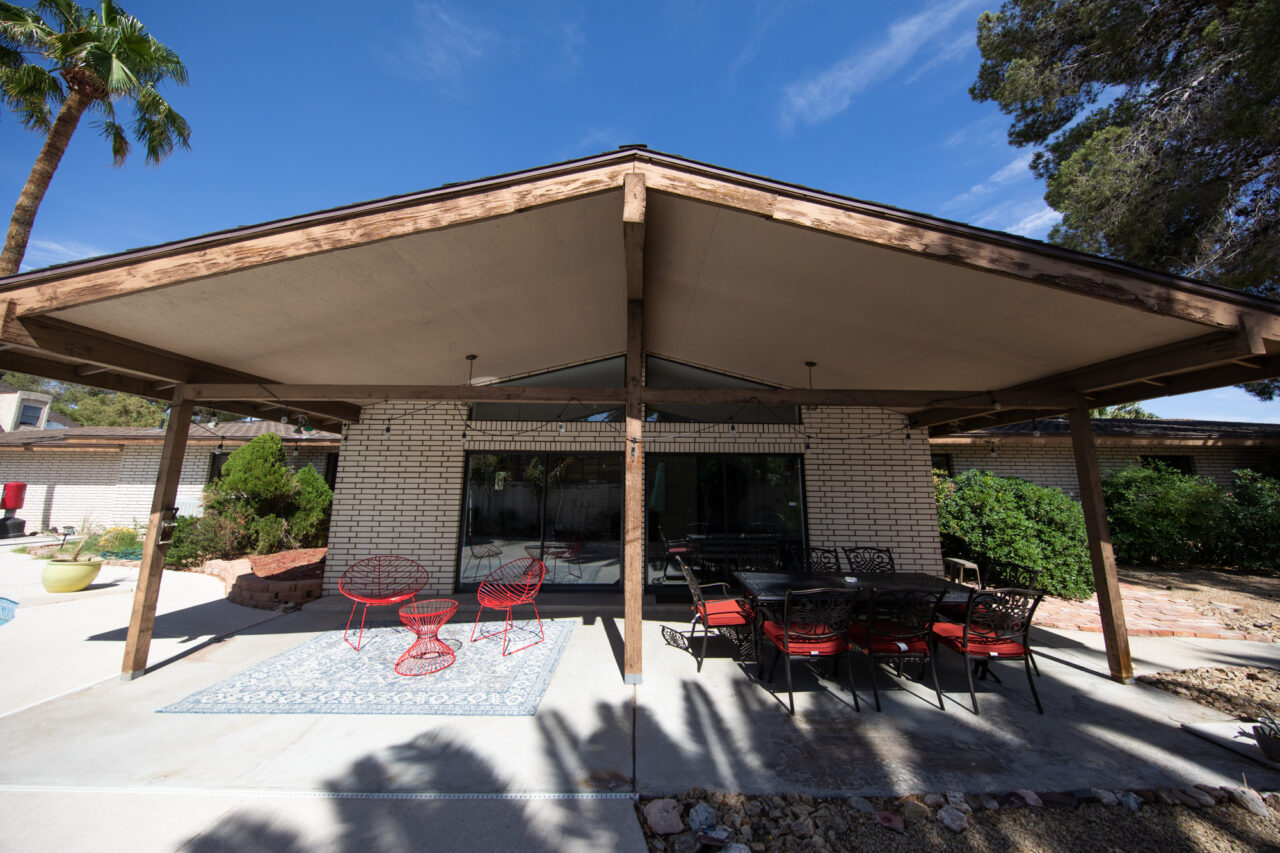 Outdoor patio with red chairs and brick walls