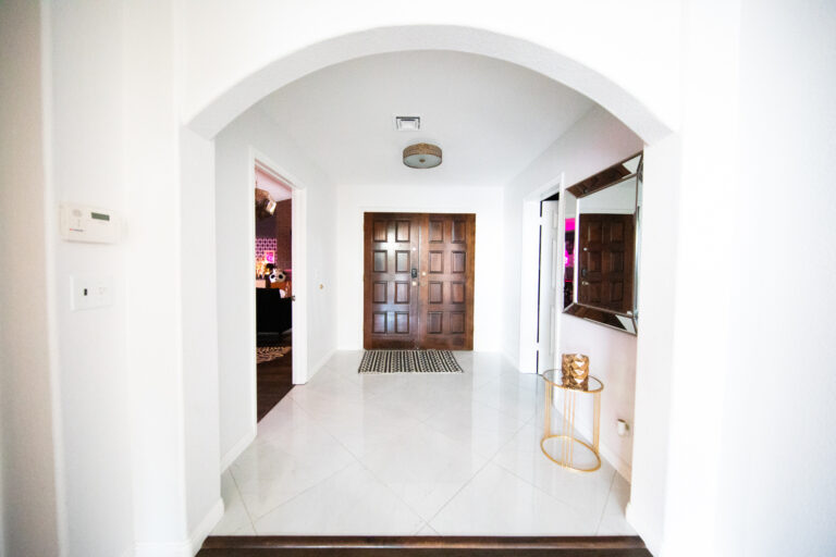 Bright arched hallway with tiled floor and wooden door