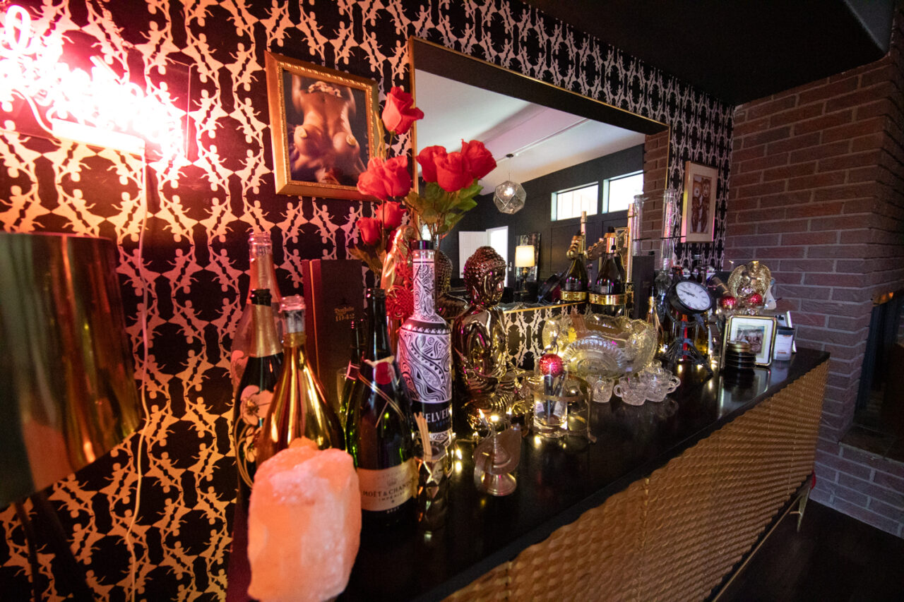 Elegant bar counter with flowers, bottles, and ornate decor