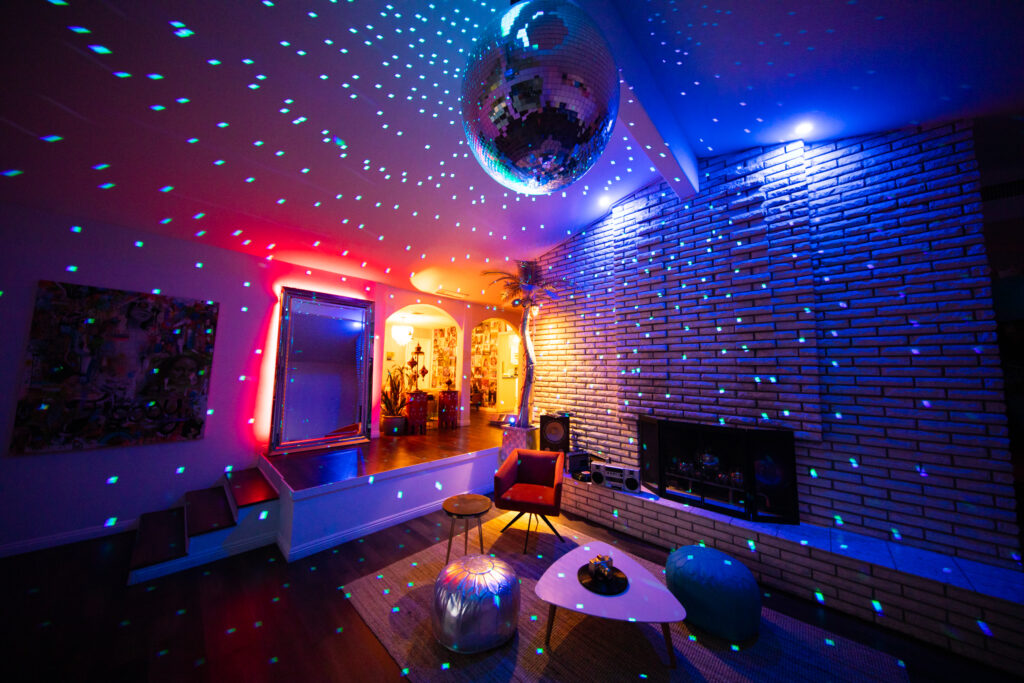 Colorful disco lights in modern living room with mirror ball