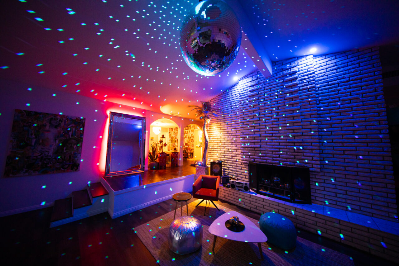 Colorful disco lights in modern living room with mirror ball