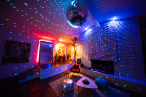 Colorful disco lights in modern living room with mirror ball