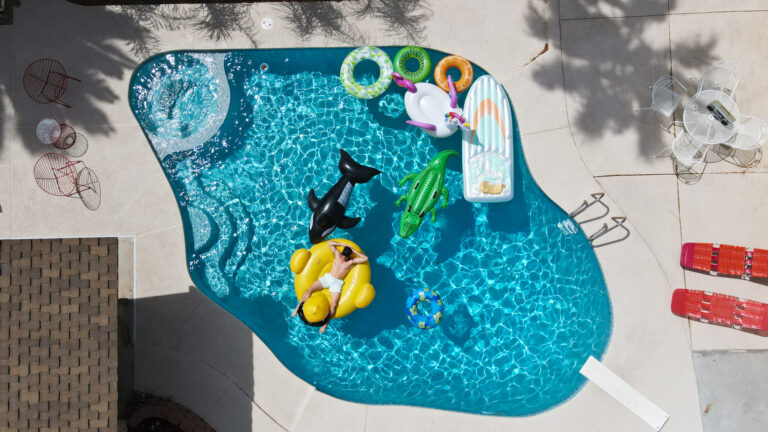 Aerial view of pool with inflatable toys and loungers